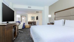 bedroom with a television, chairs, and tables